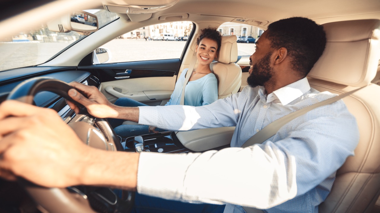 Um homem e uma mulher dirigindo em um carro.