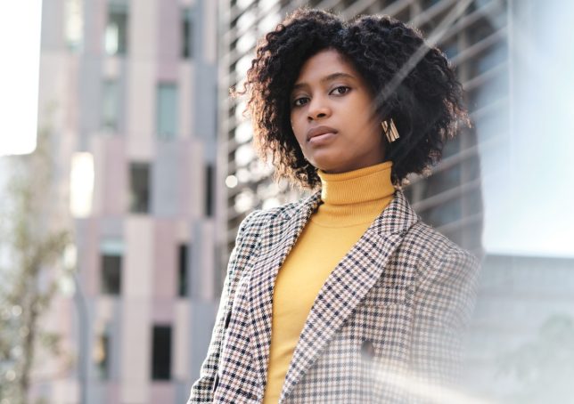 Mulher com roupas elegantes próxima a prédios de empresas